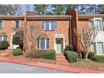 Charming brick townhouse with a manicured front garden and a bright green front door at 3454 Ashwood Ln, Atlanta, GA 30341