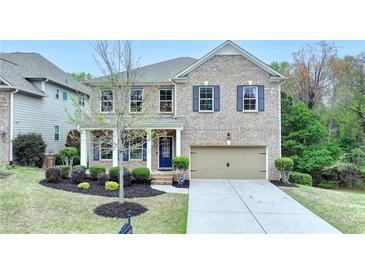 Charming brick two-story home with manicured landscaping and a two-car garage at 6845 Rocking Horse Ln, Cumming, GA 30040