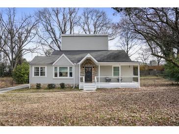 Charming grey two-story home featuring a welcoming front porch and mature trees at 1916 Cannon St, Decatur, GA 30032