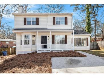 Charming two-story home featuring a welcoming front porch and manicured lawn at 594 Waynes Se Ct, Atlanta, GA 30354
