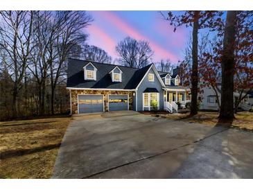 Charming home featuring a stone facade, three dormers, a two-car garage, and a spacious driveway at 1931 Amber Dawn Way, Lawrenceville, GA 30043