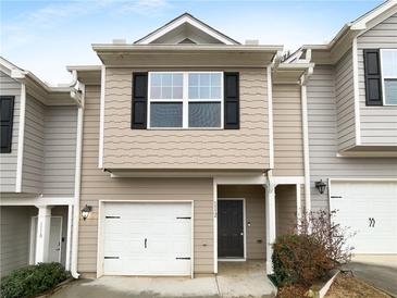 Attractive townhome with gray siding, black shutters, a white garage door, and a covered front porch at 1112 Highwood Ln, Atlanta, GA 30344