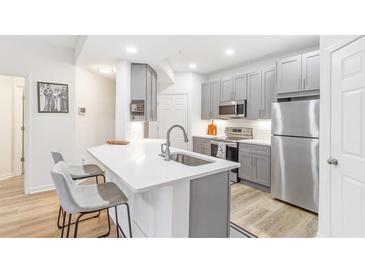 Modern kitchen with stainless steel appliances, island, and gray cabinets at 2700 Pine Tree Ne Rd # 2201, Atlanta, GA 30324