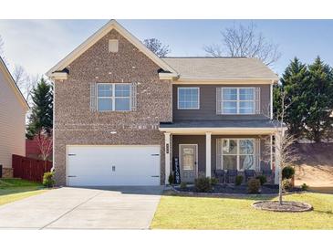 Charming two-story home with brick and siding exterior, well-maintained lawn, and attached two-car garage at 332 Hinton Farm Way, Dacula, GA 30019