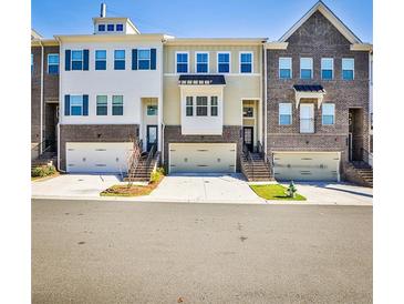 Attractive townhome row featuring brick and siding, with individual garages and landscaped front yards at 429 Stagecoach Bnd, Smyrna, GA 30080