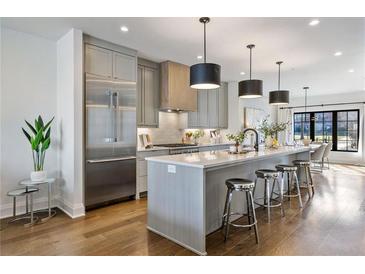 Modern kitchen with stainless steel appliances, quartz countertops, large island and pendant lighting at 726 Edgewood Ne Ave, Atlanta, GA 30307