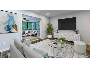 Bright living room features a comfortable couch and a view into the enclosed porch area at 80 Adrian Pl, Atlanta, GA 30327