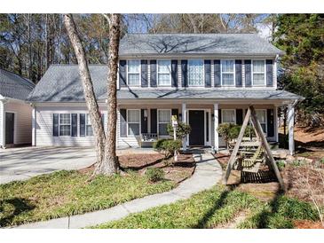 Charming two-story home featuring black shutters, a welcoming front porch, and a landscaped yard at 36 Pooles Bend Ct, Hiram, GA 30141