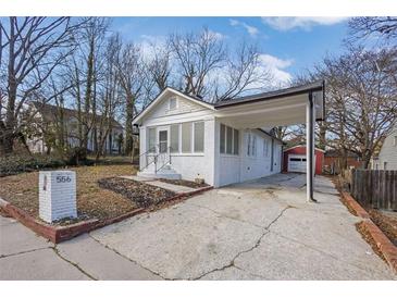Charming white brick home with a covered carport and well-maintained landscaping at 556 Holly Nw St, Atlanta, GA 30318