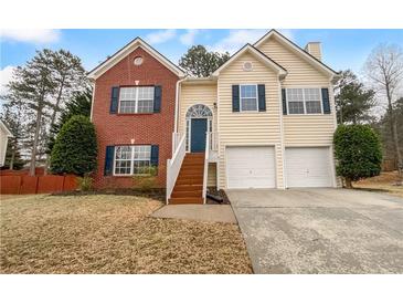 Charming two-story home with a combination brick and siding exterior, set against a backdrop of mature trees at 3519 Cast Palm Dr, Buford, GA 30519