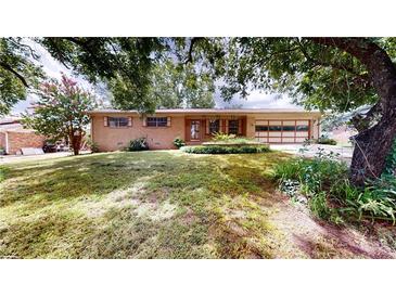 Charming brick home featuring a well-maintained front yard and an attached garage at 961 Kingston Nw Rd, Conyers, GA 30012