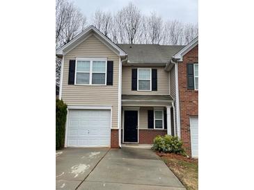 Traditional two-story townhouse with neutral siding, black shutters, and a one-car garage at 1606 Little Creek Dr, Lawrenceville, GA 30045