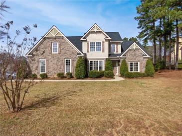 Charming brick home with symmetrical design, manicured bushes, and lush lawn at 149 Fishers Mill Dr, Mcdonough, GA 30252