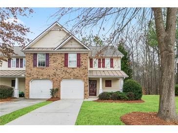 Charming townhome with brick accents, red shutters, attached garage, and well-maintained front yard at 184 Darbys Crossing Ct, Hiram, GA 30141