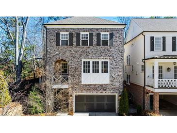 Charming brown brick two-story home with a private garage and a quaint arched balcony at 475 Rowes Cir, Alpharetta, GA 30009