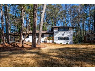 Charming two-story home featuring a carport, brick facade, and inviting entrance framed by trees at 3377 Bobolink Cir, Atlanta, GA 30311