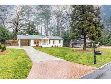 Charming one-story home featuring a brick driveway, manicured lawn, and a convenient carport at 2466 Sharondale Ne Dr, Atlanta, GA 30305