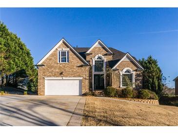 Charming brick home with well-manicured lawn, two-car garage, and beautiful architectural details at 271 Double Gate Ct, Sugar Hill, GA 30518