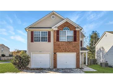 Charming two-story home featuring a dual garage, brick facade, and a well-maintained front yard at 5885 Waggoner Cv, Rex, GA 30273