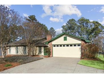 Charming single-story home featuring a brick chimney, attached garage, and a well-maintained front yard at 541 Buckingham Cir, Marietta, GA 30066