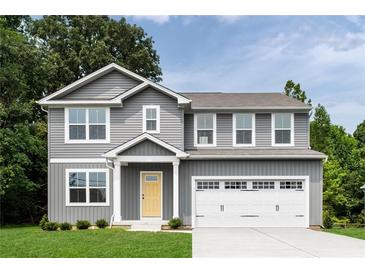 Charming two-story home with gray siding, a yellow front door, a two-car garage, and well-maintained landscaping at 812 Sweet Pine Brk, Stone Mountain, GA 30087