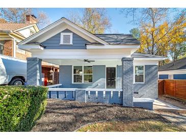 Charming bungalow featuring a covered front porch with white trim and a freshly landscaped yard at 944 Woodland Se Ave, Atlanta, GA 30316