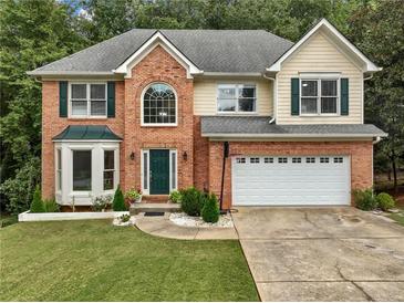 Charming two-story brick home with attached two car garage and lush front yard at 1430 Watercove Ln, Lawrenceville, GA 30043