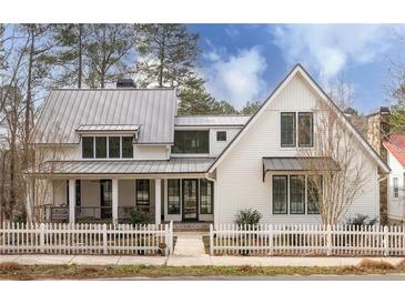 Beautiful two-story modern farmhouse with white picket fence and metal roof at 9229 Selborne Ln, Chattahoochee Hills, GA 30268