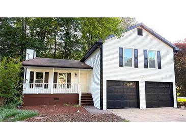 Charming two-story home with a two-car garage and white siding, nestled among mature trees at 101 Summer Pond Trl, Lawrenceville, GA 30046