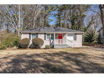 Charming single-story home with a red door, a landscaped yard, and traditional curb appeal at 1743 Thomas Ter, Decatur, GA 30032