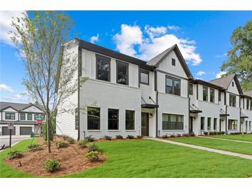 Charming new construction townhome with brick and siding exterior, green lawn and beautiful landscaping at 1330 Parc Bench Rd, Atlanta, GA 30316