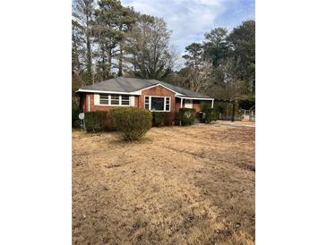 Charming brick home with a cozy front yard and mature trees, offering a serene suburban setting at 4300 Shady Lane Way, Forest Park, GA 30297