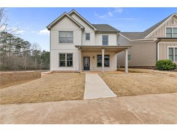 Charming two-story home featuring a covered porch, board and batten siding, and a well-manicured front yard at 5115 N Pratt St, Covington, GA 30014