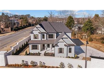 Stunning new construction home featuring a light gray facade, dark shutters and roof, and a landscaped front yard at 2711 Twisted Oak Ne Ln, Marietta, GA 30066