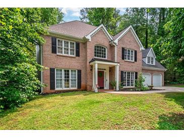 Charming two-story brick home with a manicured lawn and mature trees at 5485 Brookstone Nw Dr, Acworth, GA 30101
