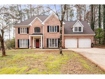 Charming brick home with a manicured lawn, black shutters and attached two-car garage at 5485 Brookstone Nw Dr, Acworth, GA 30101