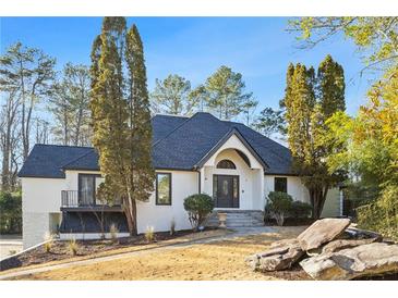 Stunning two story home featuring a landscaped front yard and an arched front entry at 11260 Houze Rd, Roswell, GA 30076