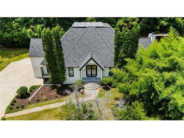 Stunning home with modern architectural design surrounded by mature trees and lush landscaping at 11260 Houze Rd, Roswell, GA 30076