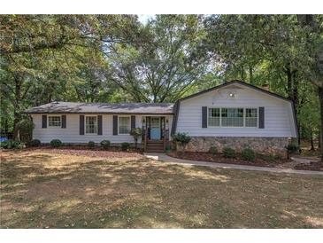 Charming single-story home with stone accents, complemented by mature trees and a well-manicured front lawn at 1240 Evans Cook Rd, Canton, GA 30115