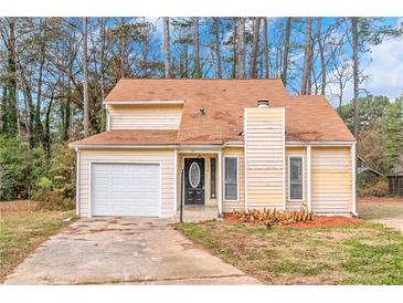 Charming two-story home with attached garage, neutral siding, and well-maintained landscaping at 1458 Walnut Log Pl, Austell, GA 30168