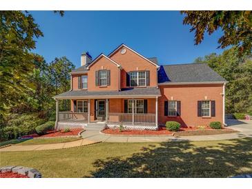 Charming two-story red brick home with a welcoming front porch and beautifully landscaped yard at 2436 Green Hollow Ct, Conyers, GA 30012