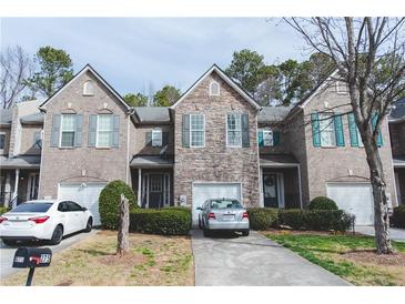 Charming townhome with a well-maintained lawn, brick and stone accents and private garages at 275 Fern Crest Dr, Lawrenceville, GA 30046