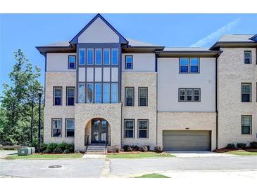 Beautiful townhome featuring a brick facade, arched entryway and attached garage at 3856 Allegretto Cir, Atlanta, GA 30339