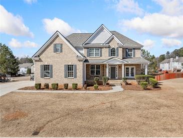 Beautiful two-story brick home featuring well-manicured landscaping and a welcoming front entrance at 1151 Nash Lee Sw Dr, Lilburn, GA 30047