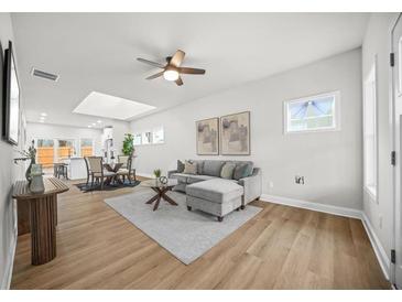 Bright, open living room with hardwood floors, modern furniture, and plenty of natural light at 395 W Lake Nw Ave, Atlanta, GA 30318