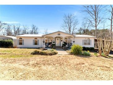 Charming single-story home with covered porch and lovely landscaping in front yard at 1370 A Cronic Town Rd, Auburn, GA 30011