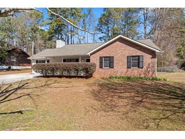 Charming brick home with mature landscaping and a well-maintained lawn at 1901 Lullwater Cir, Jonesboro, GA 30236