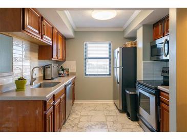 A view of the kitchen, featuring wood cabinets, light countertops, and stainless steel appliances at 795 Hammond Dr # 1812, Atlanta, GA 30328