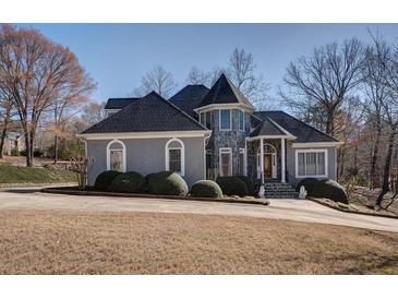 Charming home with stone accents, mature landscaping, and a circular driveway at 4610 Riversound Drive, Snellville, GA 30039