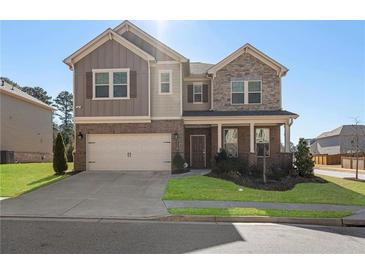 Charming two-story home with brick and stone accents, a two-car garage, and a well-manicured front lawn at 3218 Hidden Valley Cir, Lawrenceville, GA 30044